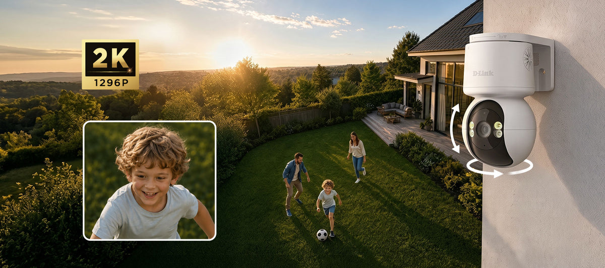 A white D-Link dome security camera mounted on a light-colored exterior wall, shown in a real backyard scene with people playing soccer and a house in the background. A small inset photo of a smiling child appears in the lower left, and a '2K 1296P' badge is in the upper left.